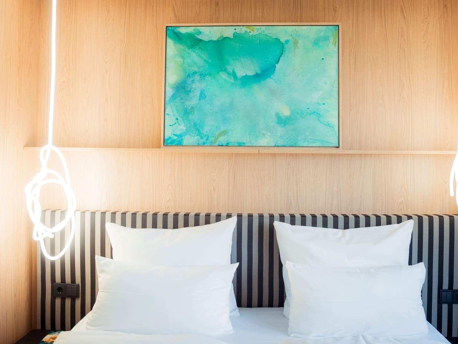 Doppelbett mit gestreiftem Kopfteil und Kunstwerk